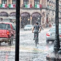 man biking during heavy rain